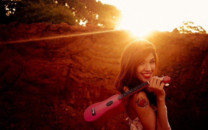жизнерадостная девушка с розовой гитарой