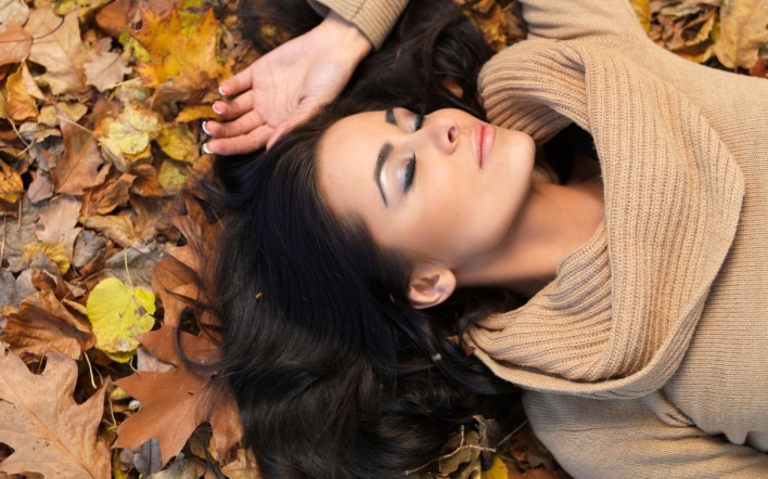 девушка брюнетка лежит на земле длинные волосы сухие листья