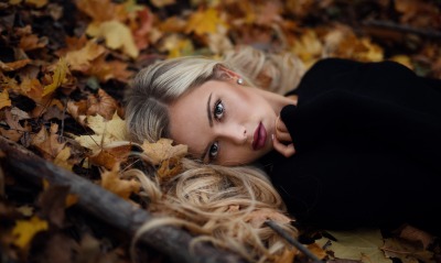 Девушка на земле в осенних листьях