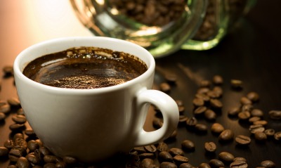 Чашка кофе в центре кофейных зерен