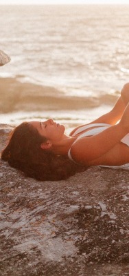 девушка лежит на камне море купальник
