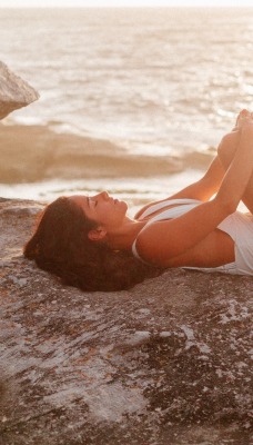 девушка лежит на камне море купальник