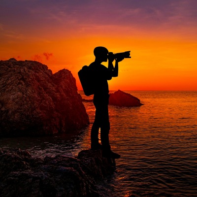фотограф на закате силуэт скалы