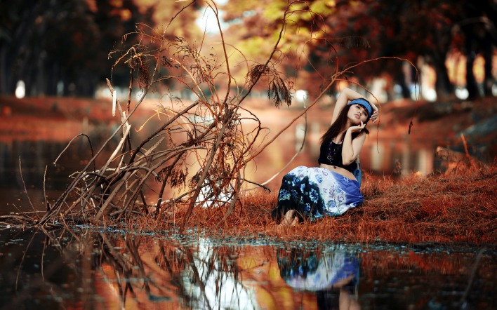 Девушка на траве у озера