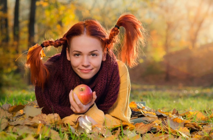 Девушка рыжая косички яблоко на земле