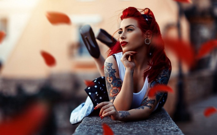 Рыжая девушка с татуировкой на плече