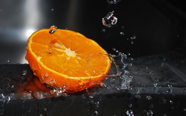 Апельсин под каплями воды