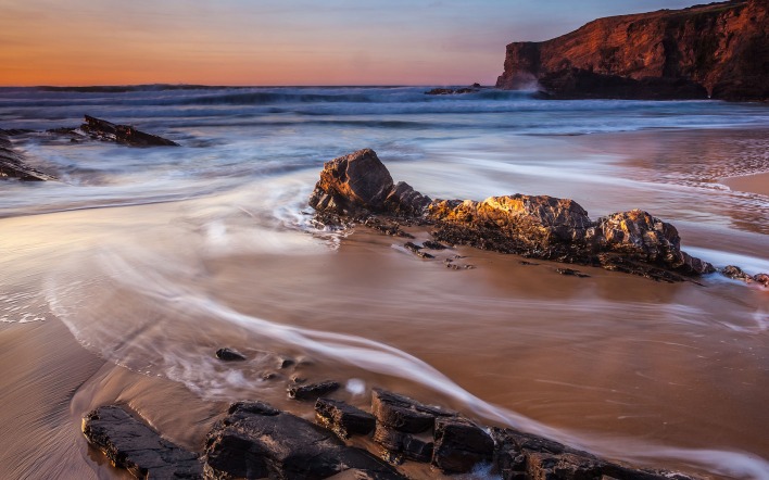 каменистое побережье во время заката