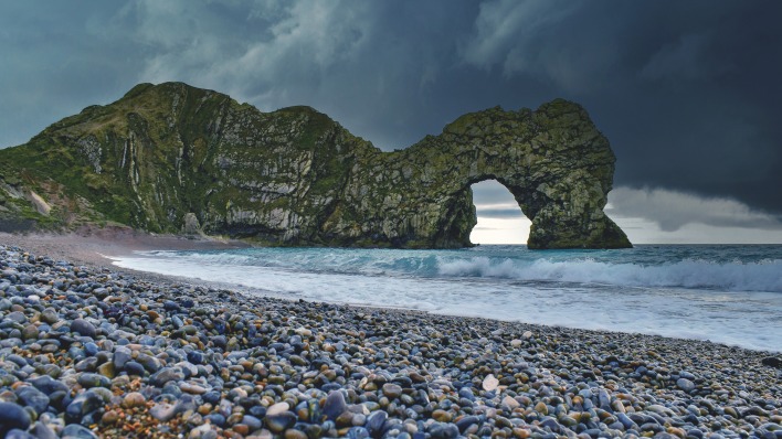 пляж галька скалы арка волны