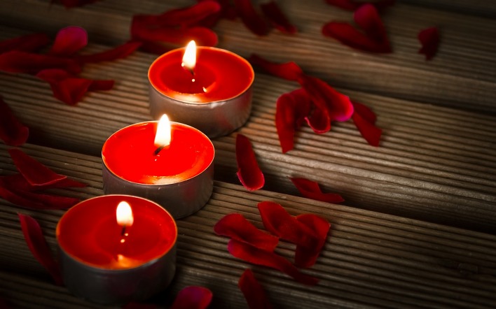 Красные свечи с лепестками роз
