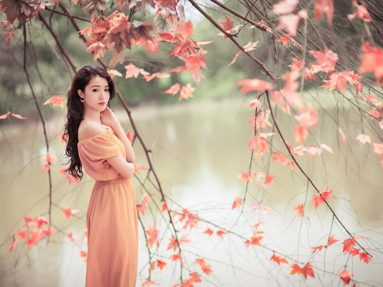 девушка азиатка ветви листья у водоема