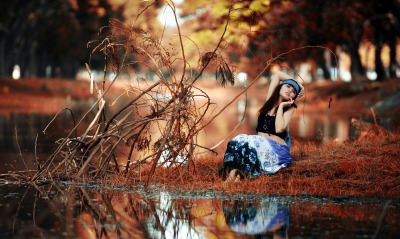 Девушка на траве у озера