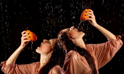Девушки с апельсином под каплями воды