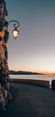 скала фонарь берег горизонт на закате