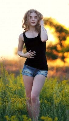 девушка милая в поле трава на закате