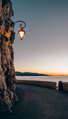 скала фонарь берег горизонт на закате