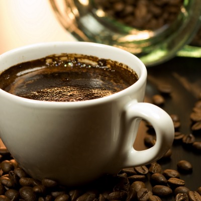 Чашка кофе в центре кофейных зерен