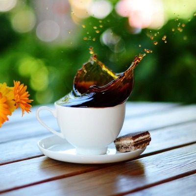 Брызги кофе на столе с цветком